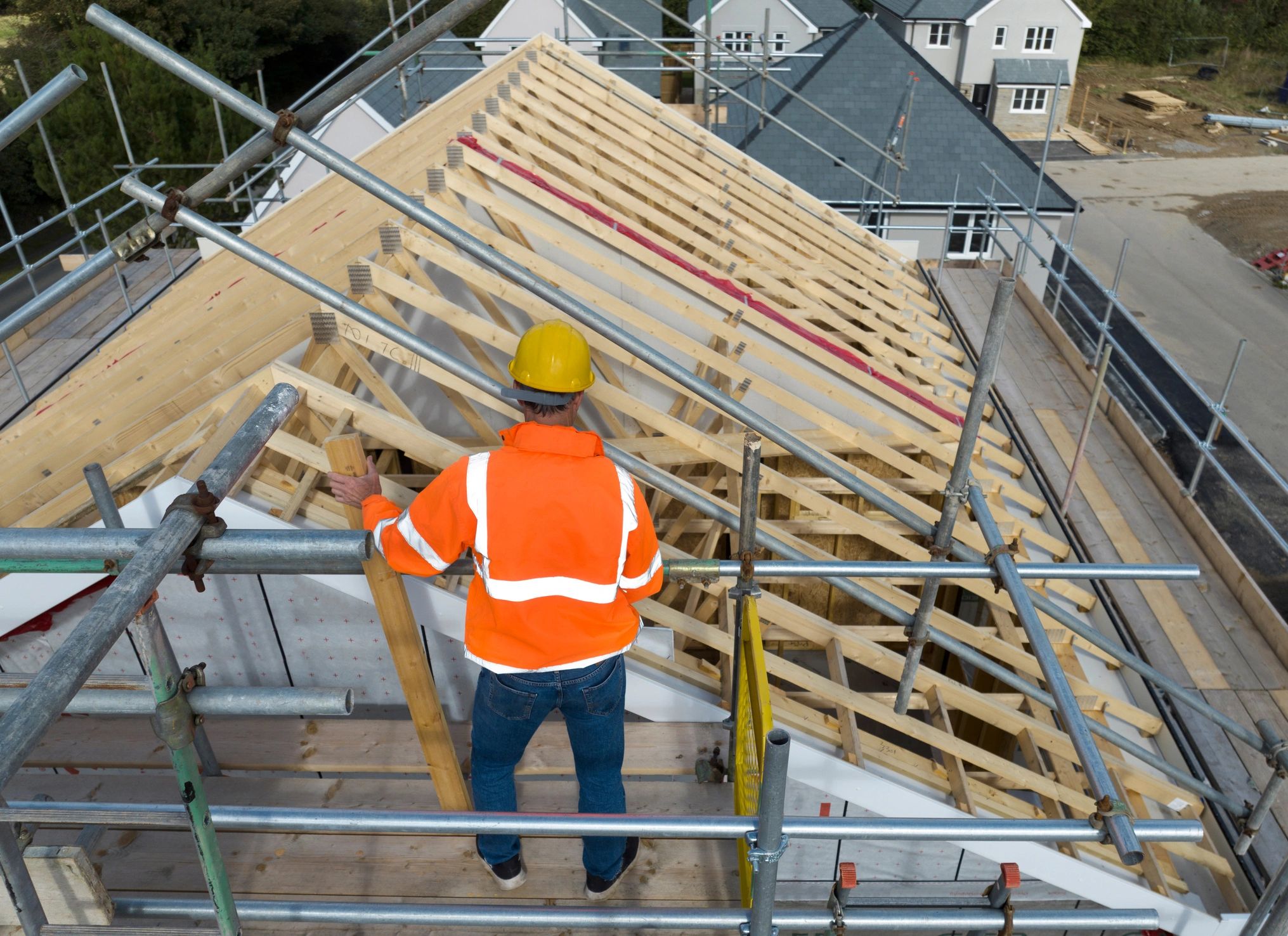 Aerial view of a construction worker working on roof trusses